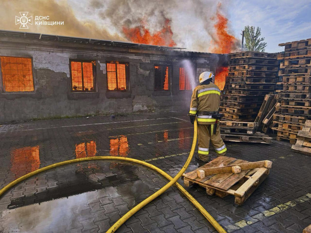 A firefighter puts out a blaze following a Russian attack in Kyiv region, Ukraine on Wednesday. (Ukrainian Emergency Service via AP)
