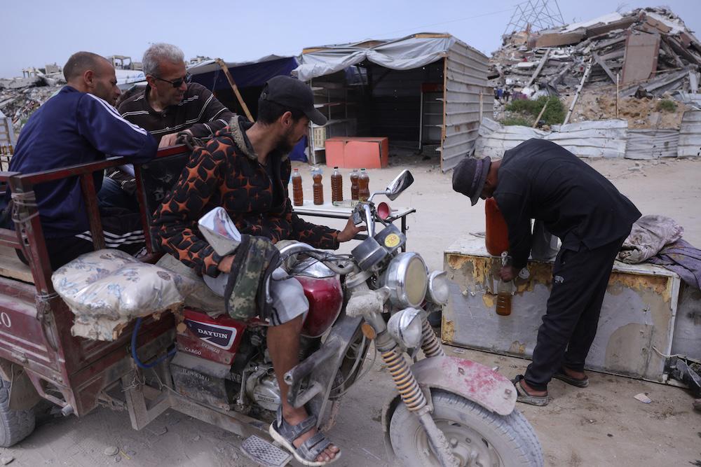 A Palestinian man sells fuel, extracted from recycled plastic at a makeshift plant, at a roadside kiosk in Jabalia in the northern Gaza Strip on April 6, 2025. (AFP)