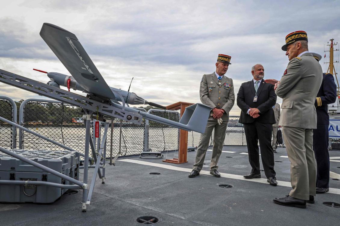 French Army Brigadier General General Eric Ozanne (L) stands with Commander of French Forces New Caledonia Major General Yann Latil (R) and French Ambassador to Australia Pierre-André Imbert (C) next to a drone aboard the French patrol vessel Auguste Benebig, which will participate in the annual Talisman Sabre exercise, in Sydney on July 13, 2025. (AFP)