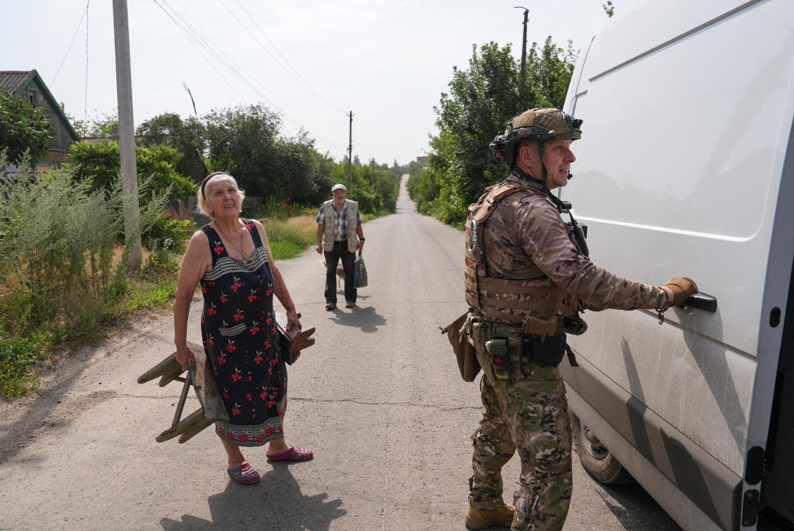A member of the White Angels police evacuation unit assists residents during an evacuation from the frontline town of Kostiantynivka in Donetsk region, Ukraine on July 12, 2025. (Reuters)
