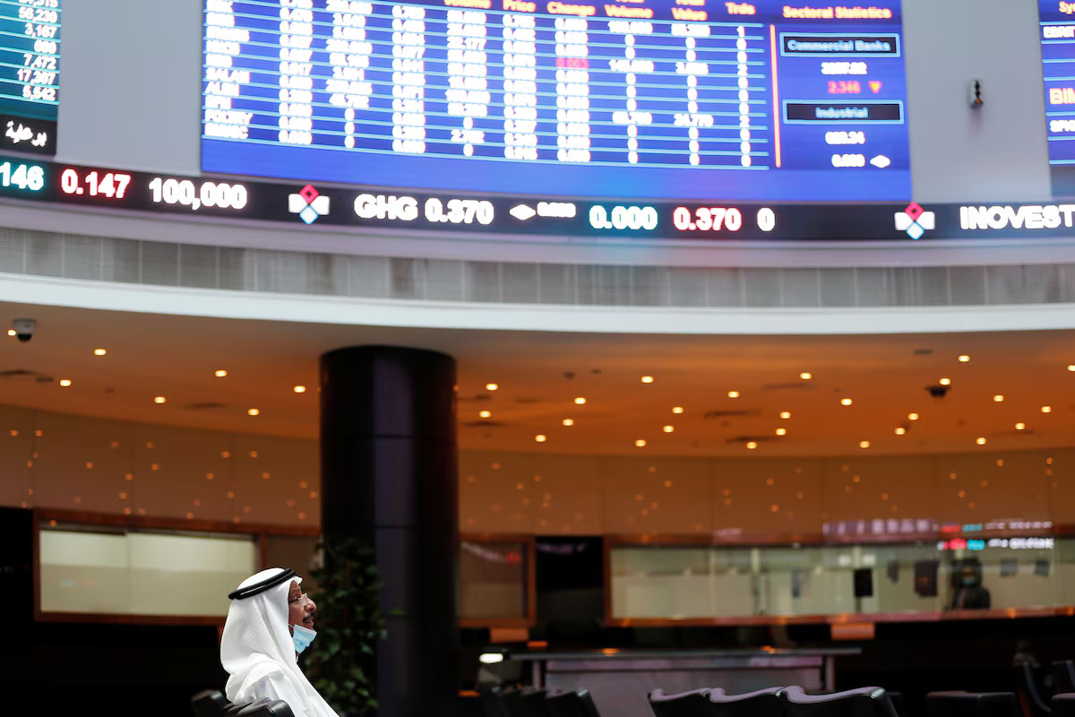 A trader looks on near electronic boards showing stock market data at Bahrain Bourse. File/Reuters