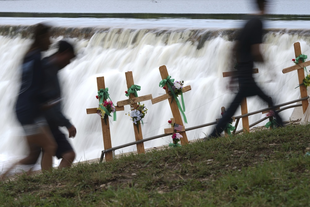 Visitors walk past crosses at a makeshift memorial honoring flood victims on July 13, 2025, in Kerrville, Texas. (AP)