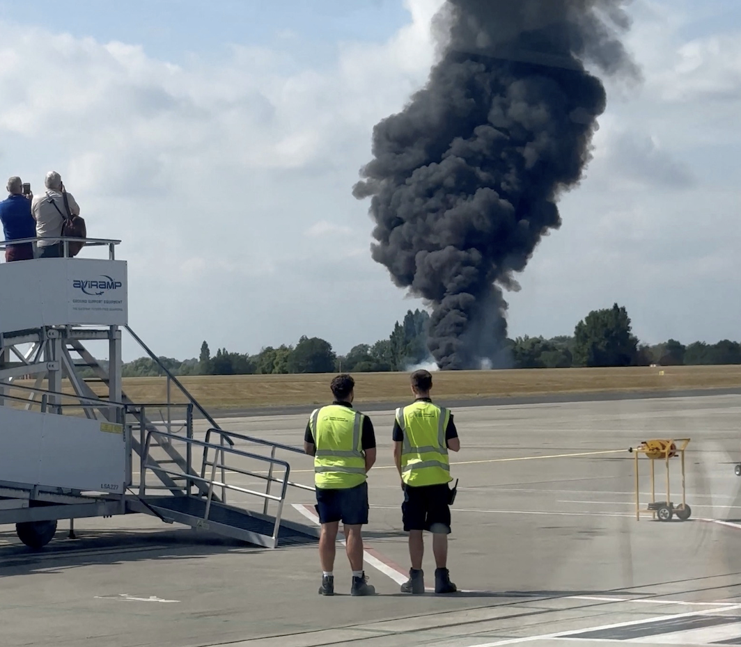 A plume of black smoke rises from an area near the runway after a small plane crash, as seen from inside a building at London Southend Airport, in Southend, Britain, July 13, 2025, in this screen grab. (Reuters)
