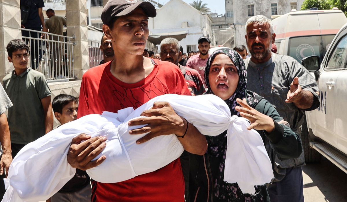 A Palestinian woman reacts as a young man carries the body of her child killed in an Israeli strike, in front of Gaza City's Maamadani (Baptist) hospital on July 13, 2025. (AFP)