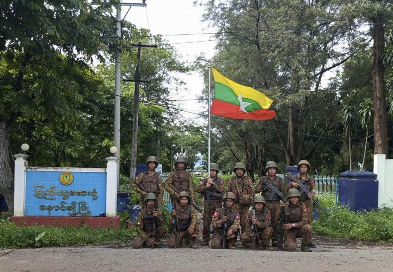 Soldiers pose for a photo in front of the captured hospital in Nawnghkio, a township that the Ta’ang National Liberation Army controlled for over a year, in northern part of Shan state, Myanmar on July 16, 2025. (The Myanmar Military True News Information Team via AP)