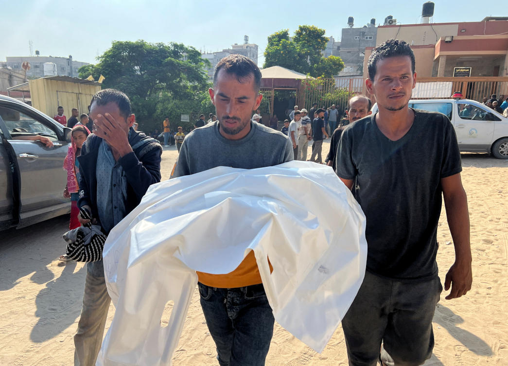 A man carries the body of a Palestinian child killed in overnight Israeli strikes, during a funeral at Nasser Hospital in Khan Younis, southern Gaza. (Reuters)