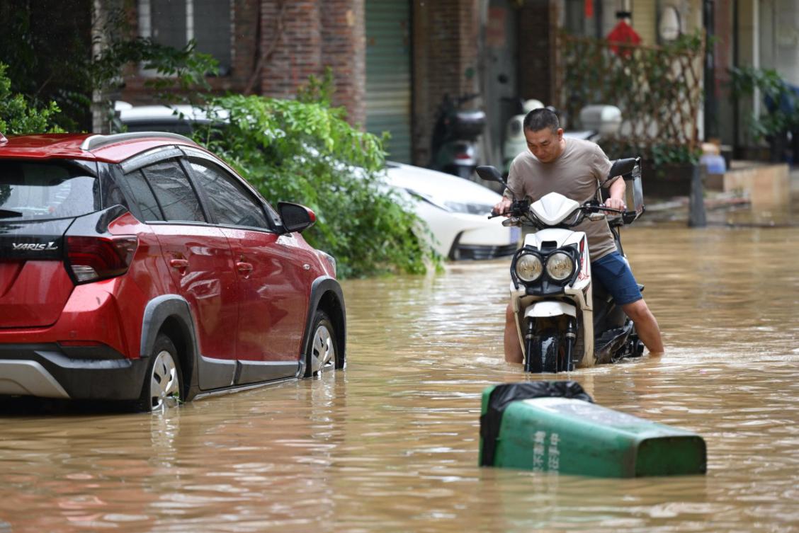 A file photo of a man rides through a flooded street in Zhongshan, in China's southern Guangdong province on June 17, 2025. (AFP)