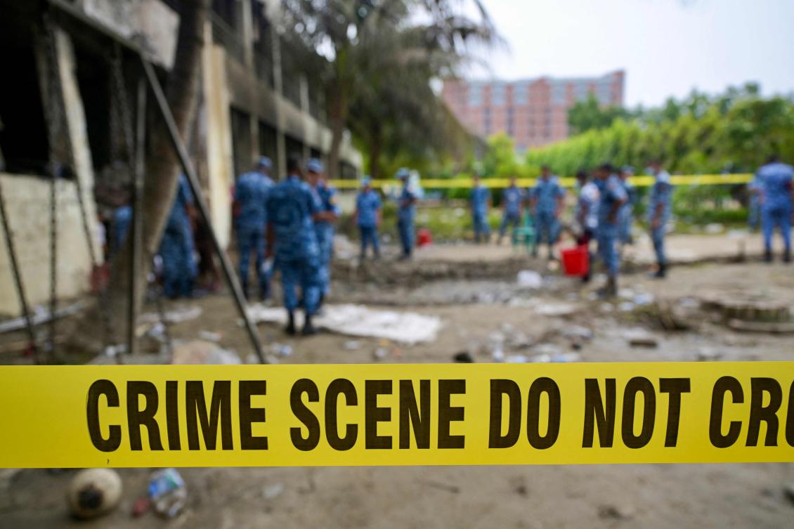 A crime scene barrier tape cordons off the area as Bangladesh Air Force personnel inspect the crash site a day after a training jet crashed into a school in Dhaka on July 22, 2025. (AFP)