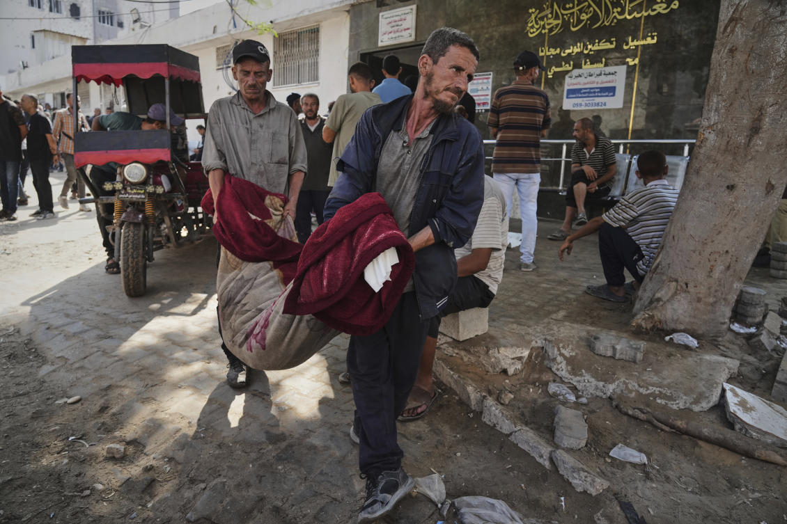 Palestinians carry the body of a person killed in an Israeli army airstrike on Gaza into Shifa Hospital in Gaza City on Tuesday, July 22, 2025. (AP)