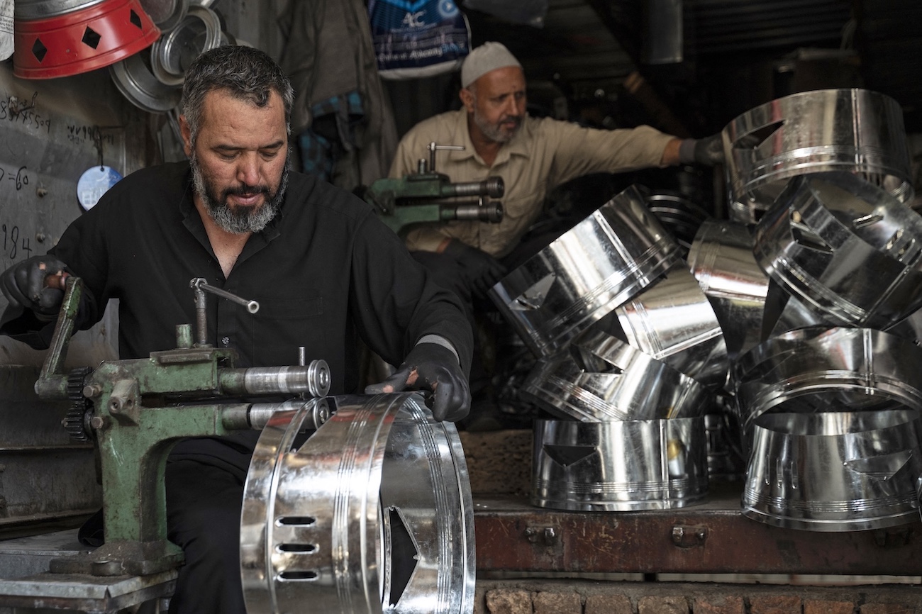 Workers make traditional tin stoves at a tin workshop in Kabul on Sept. 19, 2023. (AFP)