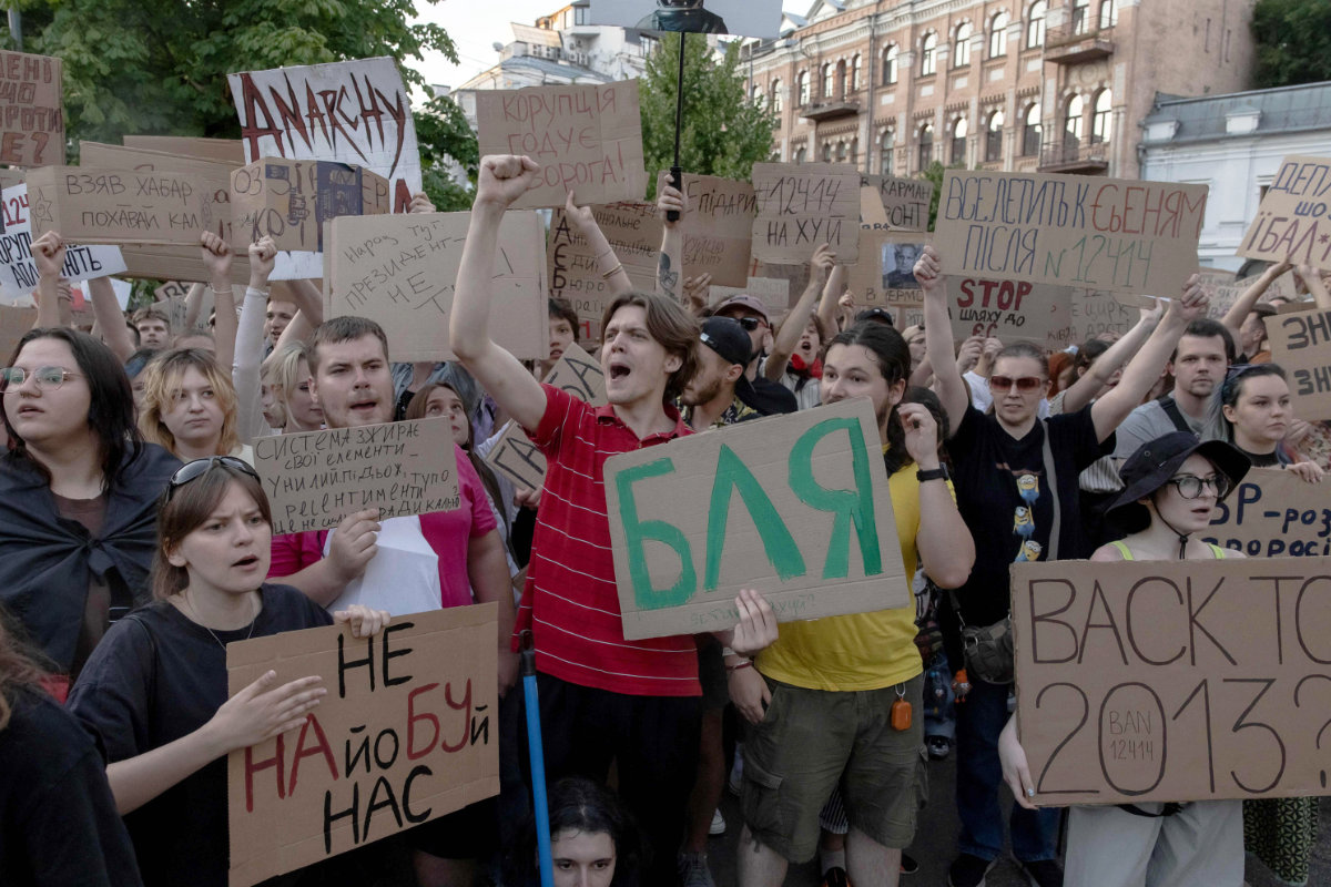 Protesters hold placards during a demonstration against a law that removes the independence of two key anti-corruption bodies in downtown Kyiv on July 23, 2025. (AFP)