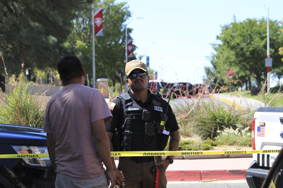 An officer talks to a delivery driver at a roadblock on the University of New Mexico campus where two people were shot, one of them fatally, in the early morning hours in Albuquerque, N.M., on July 25, 2025. (AP)