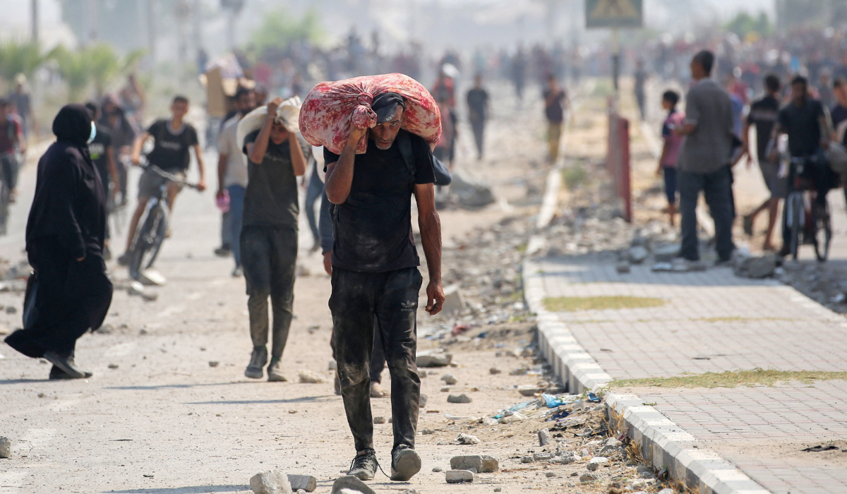 Displaced Palestinians at the Nuseirat refugee camp haul food parcels and other items they managed to get from a GHF aid distribution point at the so-called "Netzarim corridor" in the central Gaza Strip on July 26, 2025. (AFP)