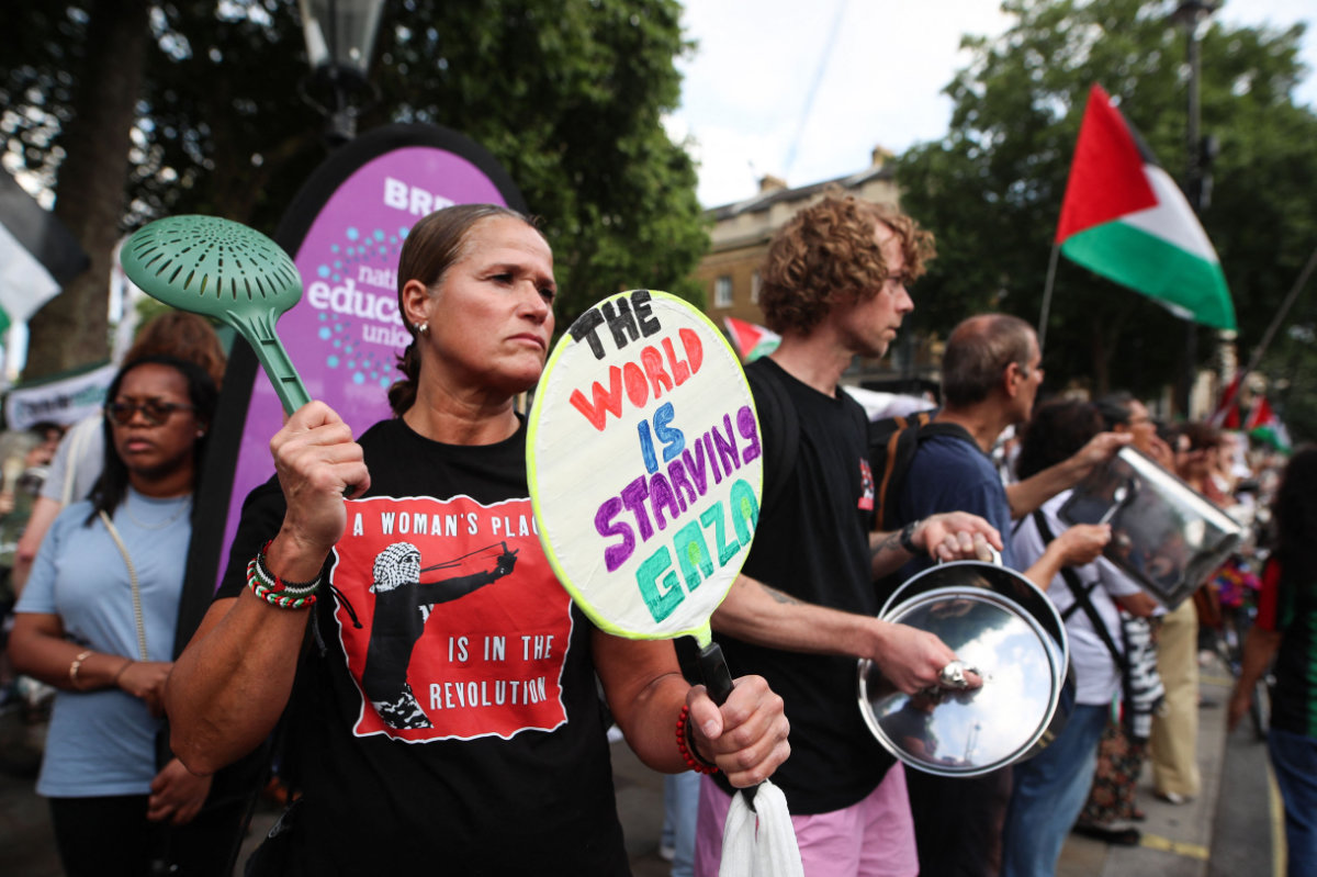 A protester holds a placard reading "Freedom for Palestine" during a demonstration outside Downing Street gates, in central London, on July 25, 2025, called by the Palestine Solidarity Campaign group to protest against the ongoing food shortages in the Gaza Strip. More than 220 British MPs, including dozens from the ruling Labour party, demanded on July 25, 2025 that the UK government formally recognise a Palestinian state, further increasing pressure on Britain's Prime Minister Keir Starmer. (Photo by Rhianna Chadwick / AFP)