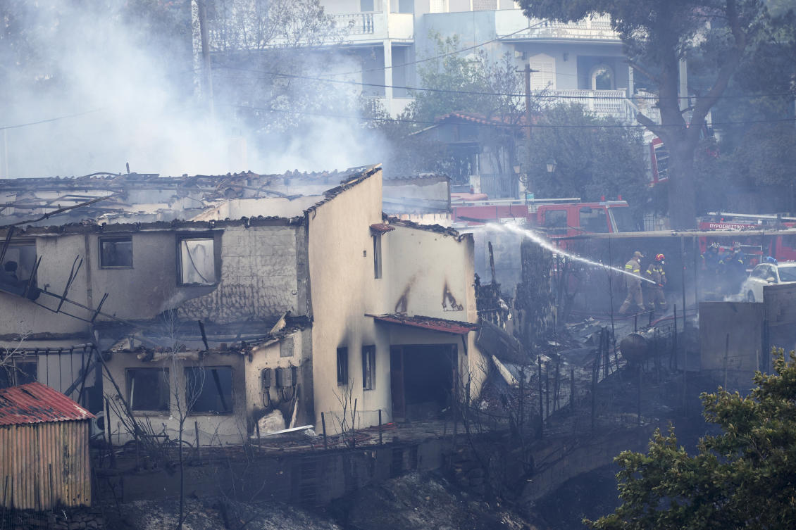 Firefighters try to extinguish a fire at a house during a wildfire in the northwestern suburb of Kryoneri, in Athens, Greece on July 26, 2025. (AP)