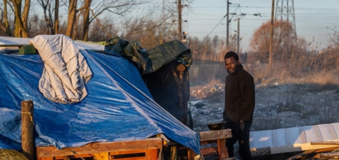 Sudanese man stands next to his tent in a migrant camp in Loon-Plage, France. (AFP)