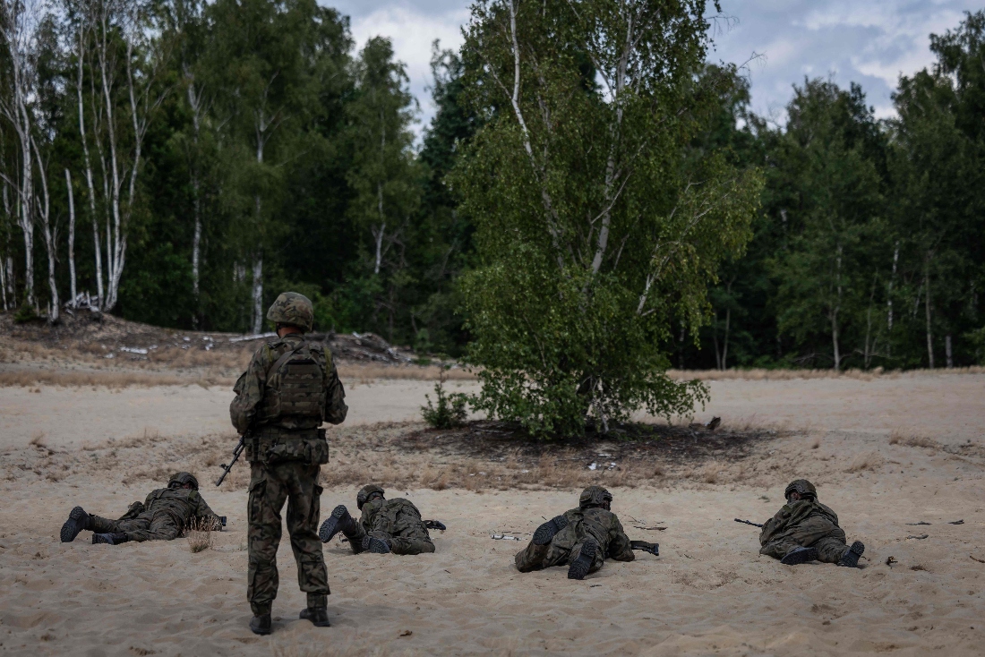A military instructor keeps an eye on volunteers during a military training that is part of the "Vacation with the Army" project, at a military shooting range on the outskirts of Warsaw, Poland. (AFP)