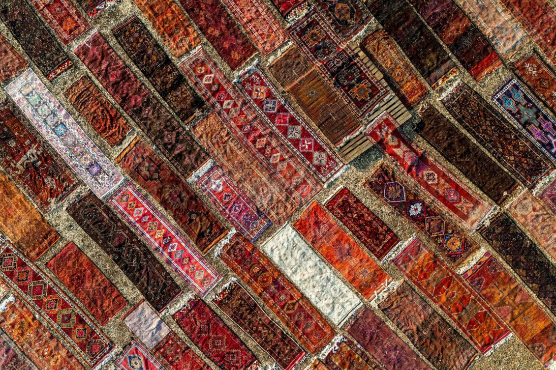 An aerial view shows handwoven carpets laid out in the open fields to soften their colors under sizzling sun in Dosemealti district in Antalya on July 22, 2025. (AFP)