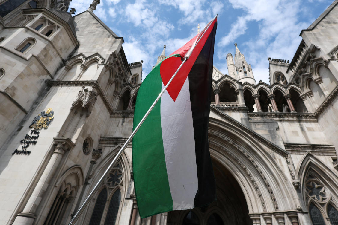 A Palestinian flag is seen, outside London's High Court as judges decide whether the co-founder of Palestine Action can challenge the UK government's ban on the group. (Reuters)