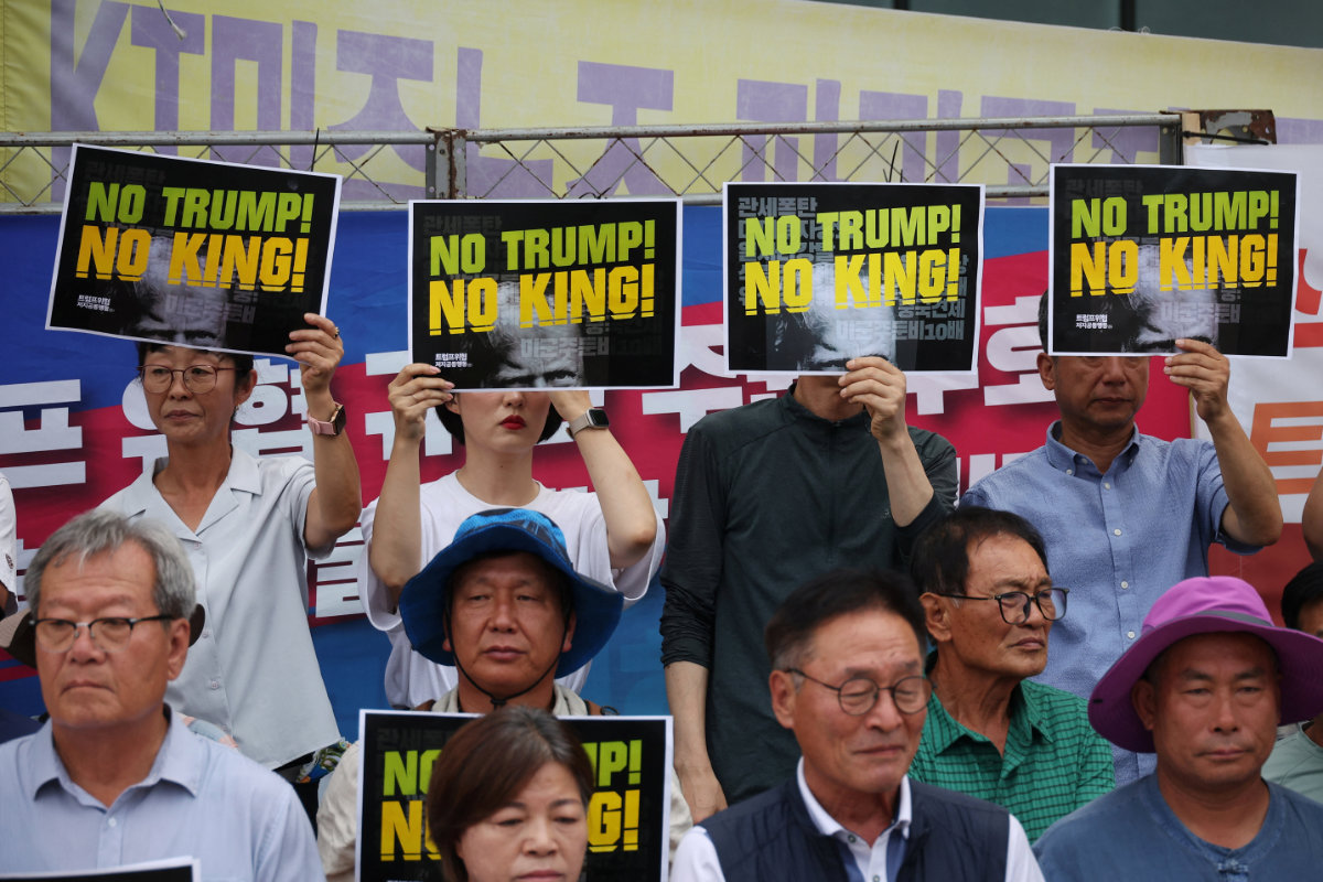 Activists hold signs during a protest against US President Donald Trump's tariffs policy near the US Embassy in Seoul, South Korea, on July 31, 2025. (REUTERS)