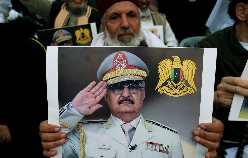 A Libyan man carries a picture of Khalifa Haftar in Benghazi, Libya, Apr. 12, 2019. (Reuters)