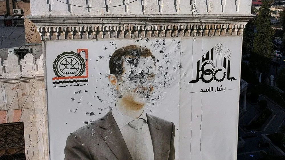 An image of Bashar Assad, riddled with bullets, in Hama, Syria, Dec. 6, 2024. (AFP)