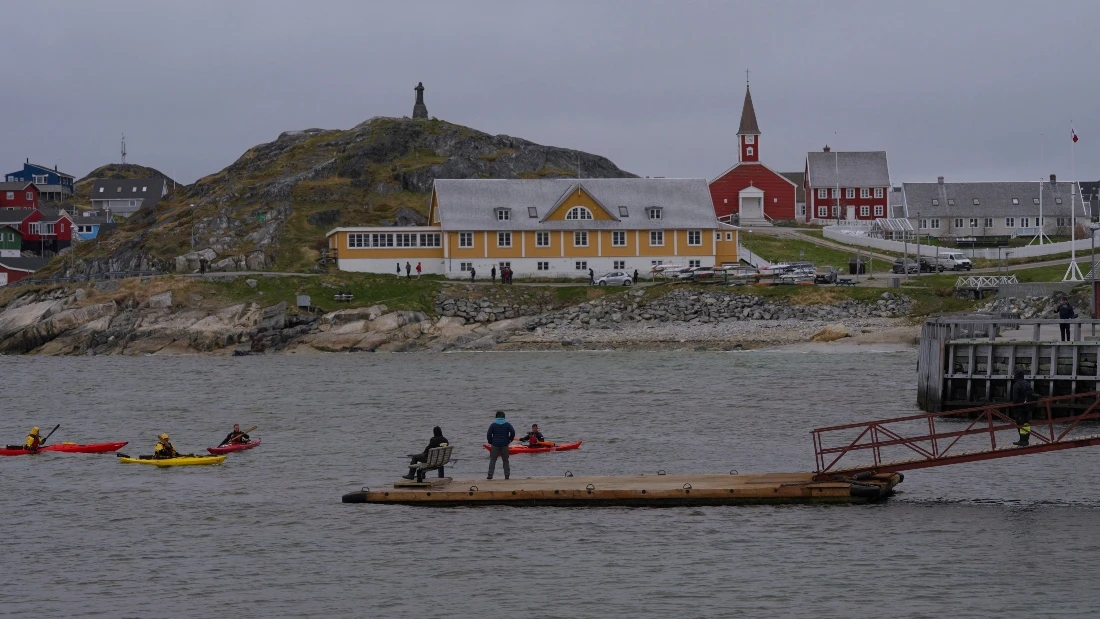 Tourists kayak at sea in front of Nuuk Cathedral in Greenland. (AP)