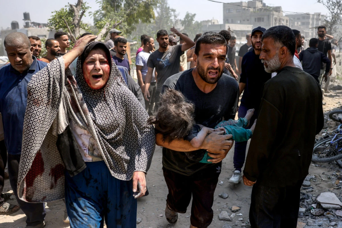 A Palestinian woman reacts as a man carries an injured child pulled from the rubble of the Shaheen family home that was targeted in an Israeli strike in the Saftawi neighborhood, Jabalia, in the northern Gaza Strip on June 9, 2025. (AFP)