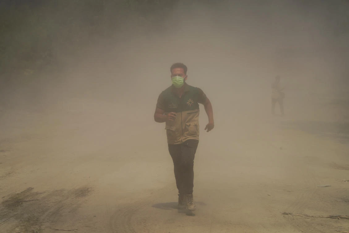 A volunteer runs through smoke from a wildfire, in Latakia countryside, Syria, July 6, 2025. (Reuters)