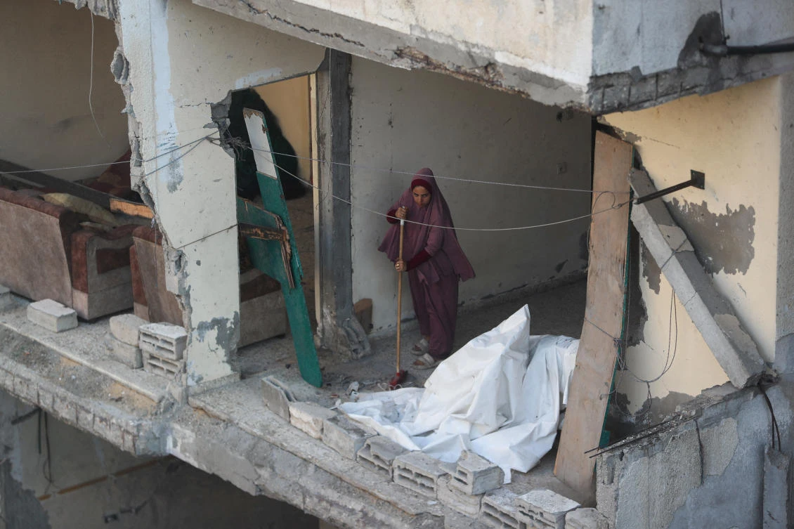 A Palestinian woman sweeps the floor at the site of an overnight Israeli strike on a house, at Shati (Beach) refugee camp in Gaza City, July 9, 2025. (Reuters)