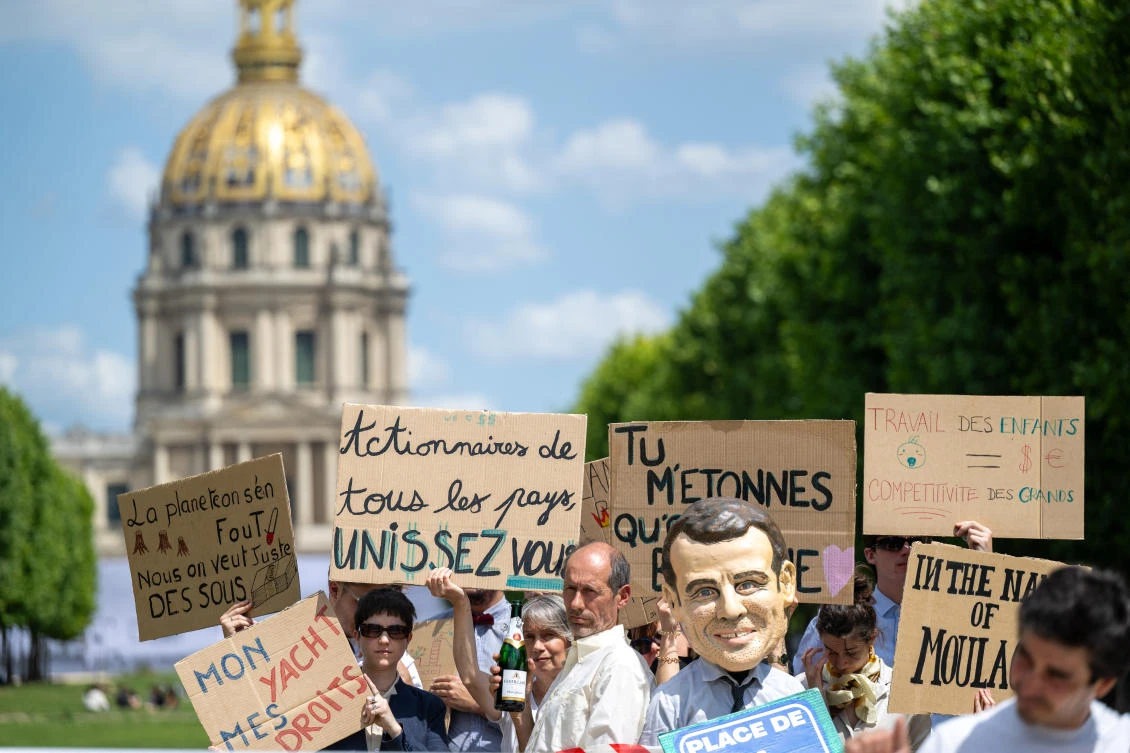 Activists from Amnesty International France and others NGOs hold placards during a symbolic action against the European Omnibus directive, a package of measures designed to simplify the social and environmental legislation applying to companies, in Paris on June 17, 2025.(File/AFP)