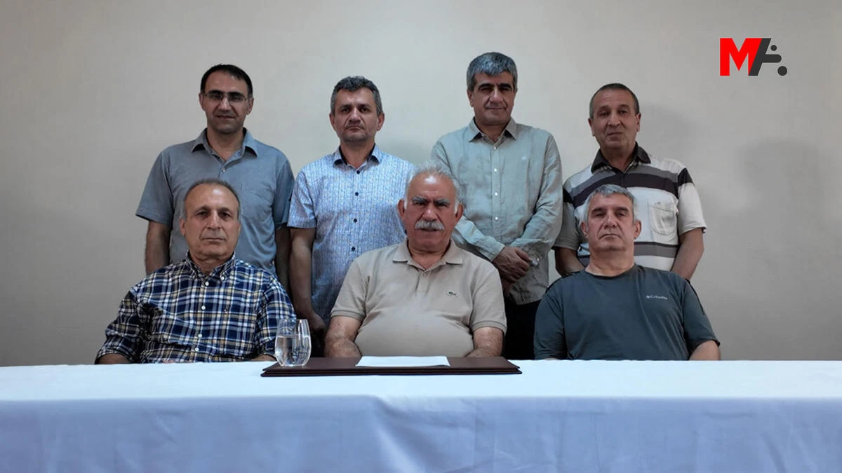 The jailed leader of the Kurdistan Workers' Party (PKK) Abdullah Ocalan (front C) sitting with jailed PKK members as he addresses supporters ahead of a disarmament ceremony. (Mezopotamya News agency handout via AFP)