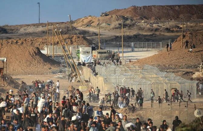 Palestinians gather at an aid distribution point set up by the Gaza Humanitarian Foundation, near the Nuseirat refugee camp in the central Gaza Strip last month. (AFP)