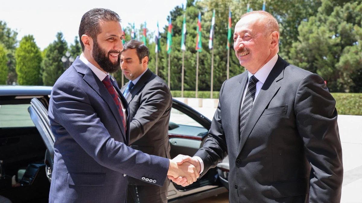 This handout picture released by the Syrian Presidency shows Azerbaijan’s President Ilham Aliyev (R) receiving Syria’s interim President Ahmed Al-Sharaa in Baku on July 12, 2025. (AFP via handout Syrian Presidency)