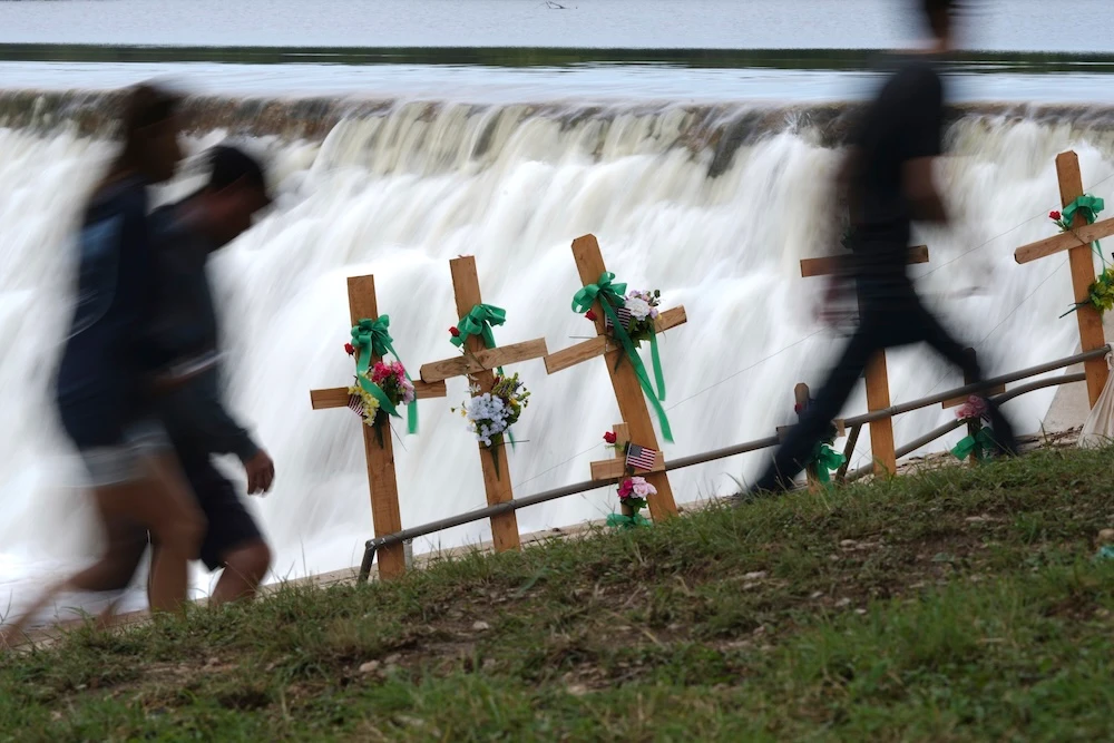 Visitors walk past crosses at a makeshift memorial honoring flood victims on July 13, 2025, in Kerrville, Texas. (AP)