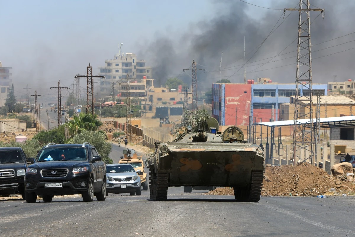 Members of Syria's security forces drive through the predominantly Druze city of Sweida, July 15, 2025. (AFP)