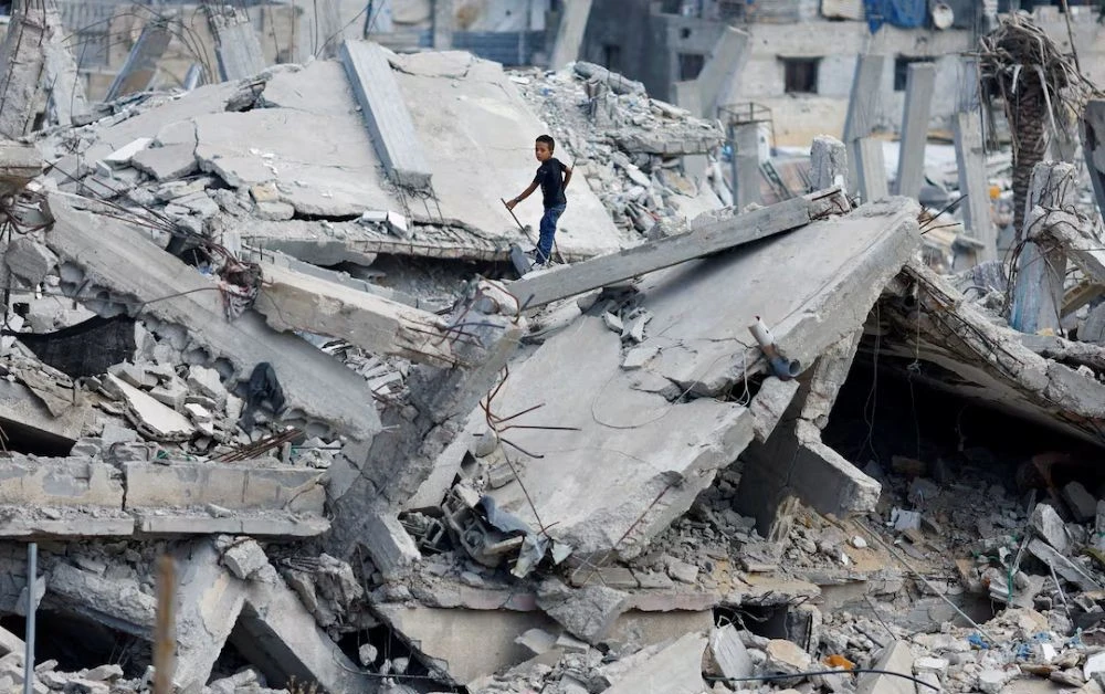 A Palestinian boy stands on the rubble of a house destroyed in Israel’s military offensive, amid the ongoing conflict between Israel and Hamas, Khan Younis, southern Gaza Strip, Oct. 7, 2024. (Reuters)