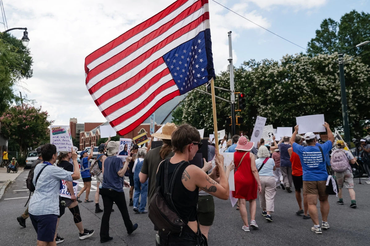 A protester holds an upside-down American flag during a "Good Trouble Lives On" rally on July 17, 2025 in Atlanta, Georgia. (Getty Images via AFP)