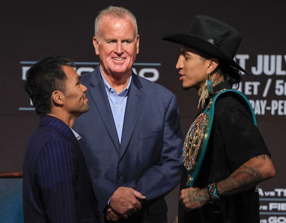 TGB Promotions President Tom Brown, center, looks on as Manny Pacquiao, left, and WBC welterweight champion Mario Barrios face off during their news conference at MGM Grand Hotel & Casino on Wednesday in Las Vegas, Nevada. (Getty Images via AFP)