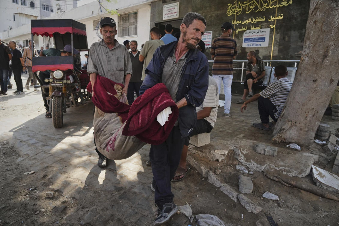Palestinians carry the body of a person killed in an Israeli army airstrike on Gaza into Shifa Hospital in Gaza City on Tuesday, July 22, 2025. (AP)