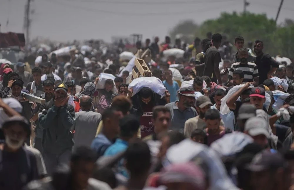 Palestinians carry aid delivered by the Gaza Humanitarian Foundation (GHF) in Rafah, June 9, 2025 (AP Photo)