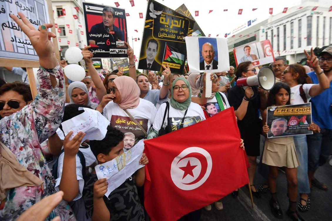 People hold placards and shout slogans as they take to the streets of Tunis to protest against President Kais Saied on July 25, 2025. (AFP)