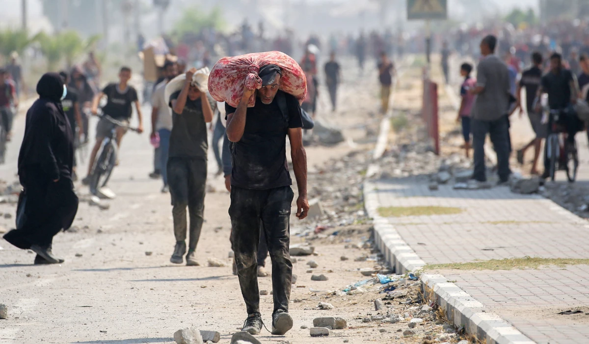 Displaced Palestinians at the Nuseirat refugee camp haul food parcels and other items they managed to get from a GHF aid distribution point at the so-called "Netzarim corridor" in the central Gaza Strip on July 26, 2025. (AFP)