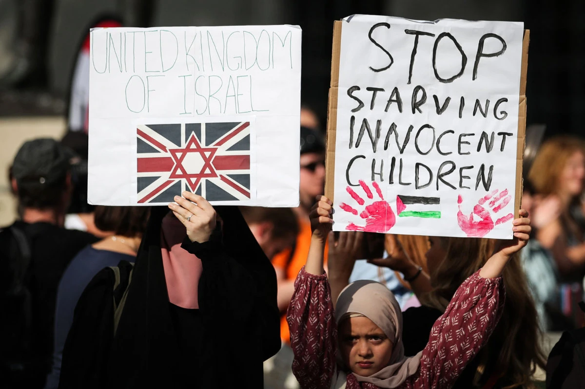 Protesters holds placards during a demonstration outside Downing Street gates, in central London, on July 25, 2025, called by the Palestine Solidarity Campaign group to protest against the ongoing food shortages in the Gaza Strip. (AFP)