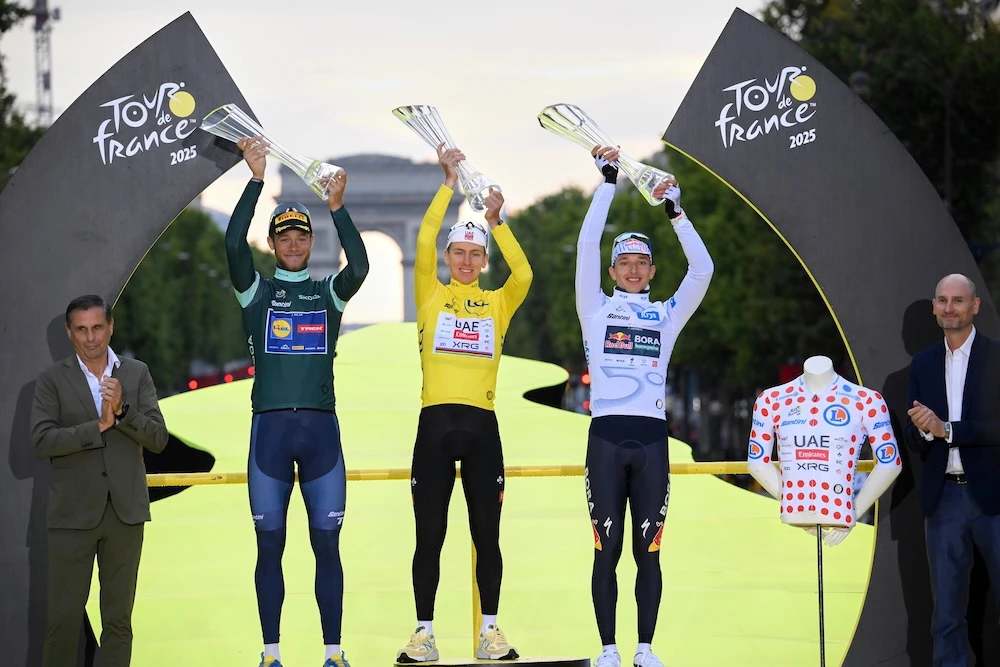 Italy’s Jonathan Milan, the best sprinter, Slovenia’s Tadej Pogacar, the Tour de France winner, and Germany’s Florian Lipowitz, the best young rider, from left, celebrate during the presentation ceremony for the Tour de France on the Champs-Elysees in Paris on Sunday. (Pool photo via AP)