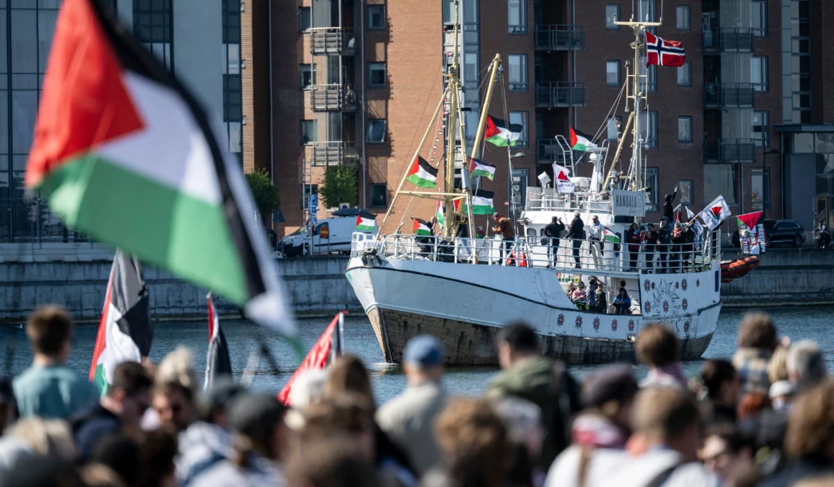 Demonstrators carrying Palestinian flags look on as the Ship to Gaza boat 'Handala' arrives at the port of Malmö, Sweden, Wednesday, May 8, 2024. (AP)