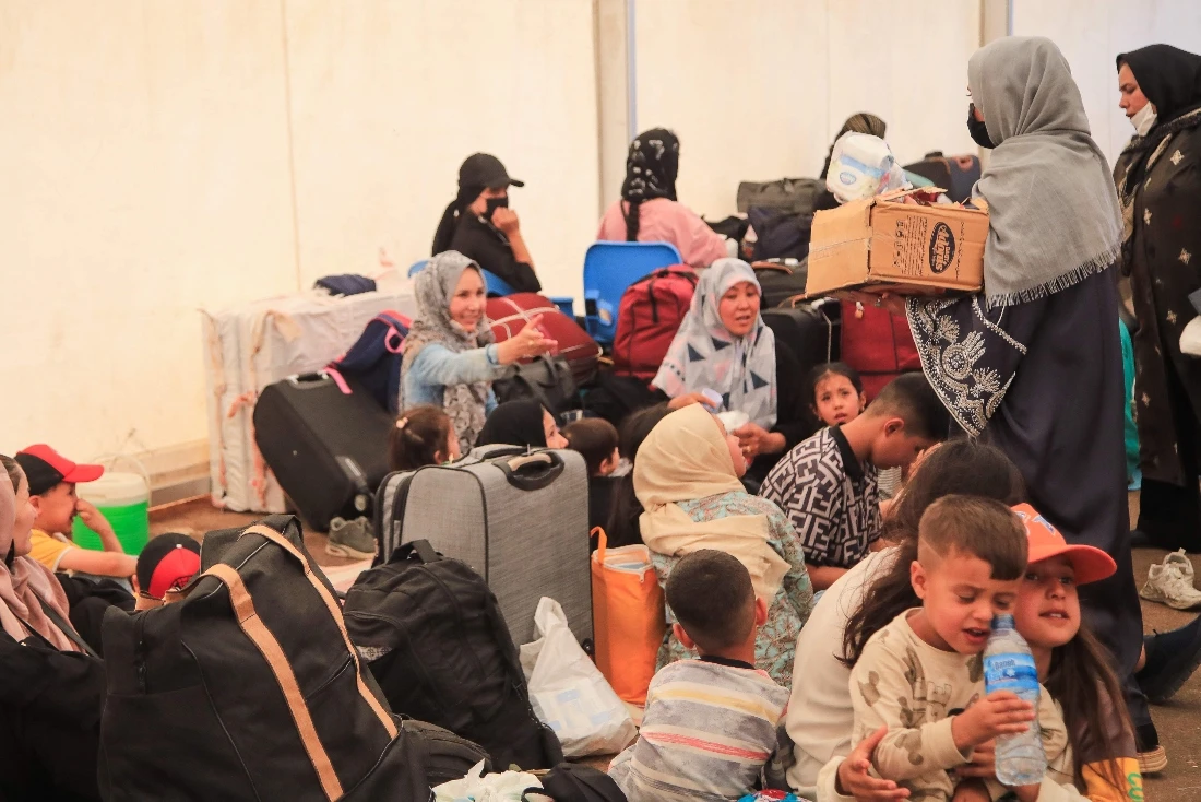 Afghan volunteers distributing relief supplies to the newly arrived Afghan migrants deported from Iran, inside a humanitarian tent at the Islam Qala border crossing in Herat province. (AFP)