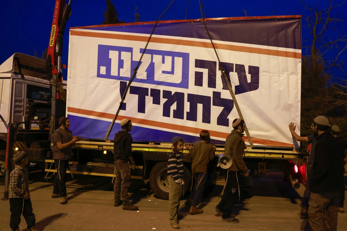 Israeli right-wing activists load a mobile house bearing a slogan which reads in Hebrew ‘Our Gaza Forever’ onto a truck in the southern town of Sderot near the border with Gaza. (File/AFP)