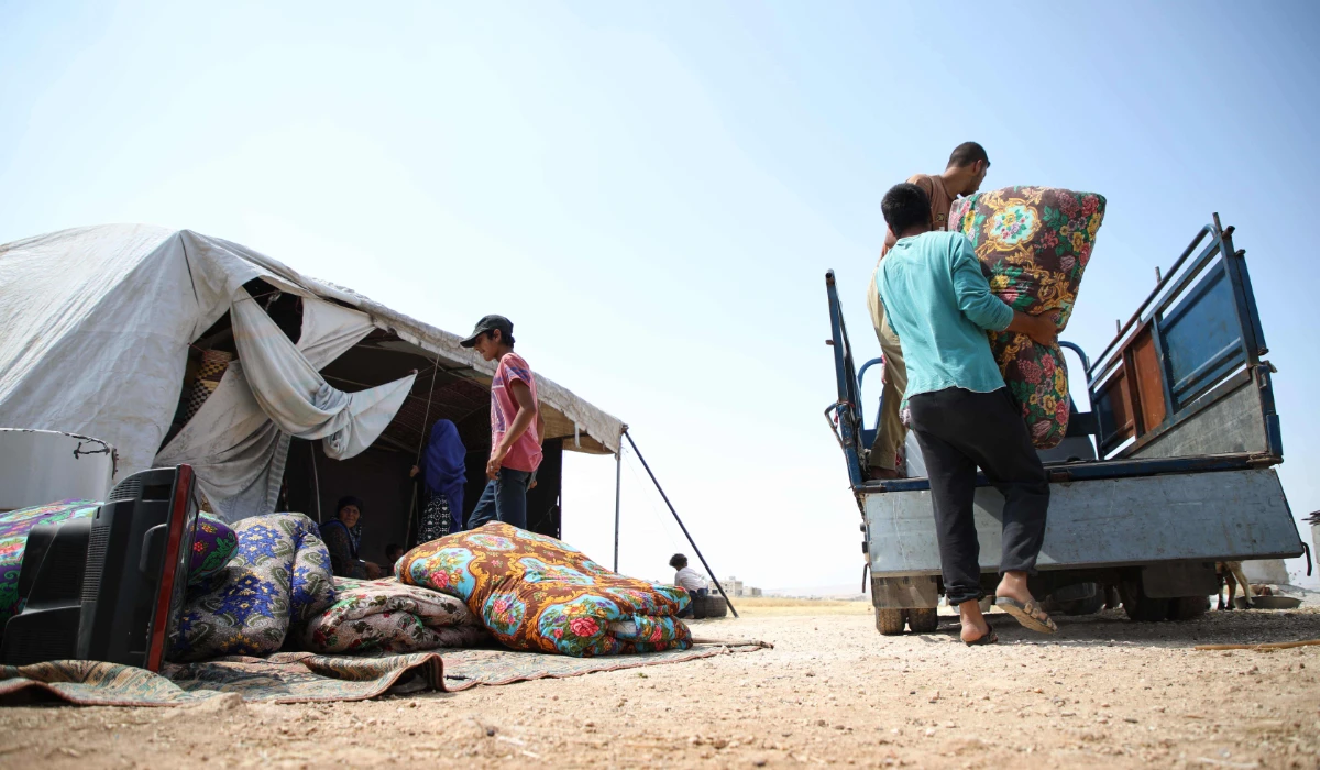 Displaced Syrian men pack their belongings into a truck as they head to sell them on the outskirts of the Syrian town of Abyan, in the rebel-held western Aleppo province, on June 13, 2019. (AFP file photo)