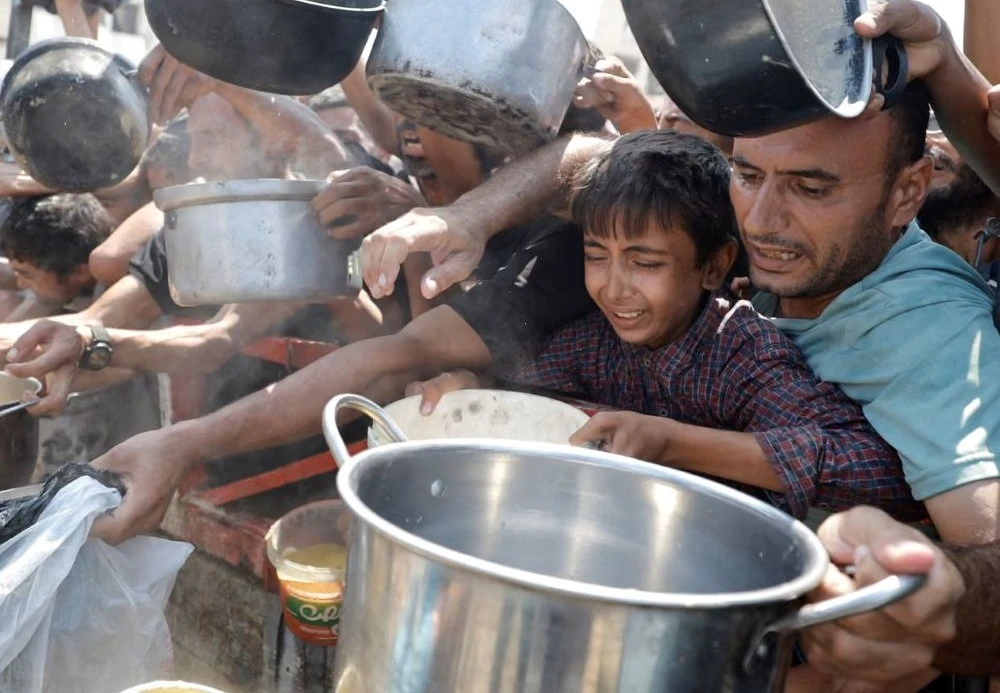 Palestinians gather to receive food from a charity kitchen in Gaza City, July 28, 2025. (Reuters)